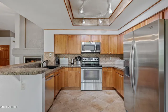 a kitchen with stainless steel appliances granite countertop a stove a sink and a microwave