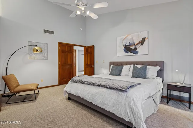 a bedroom with a bed a window and a flat screen television