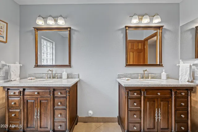 a bathroom with a granite countertop sink a mirror and a bathtub