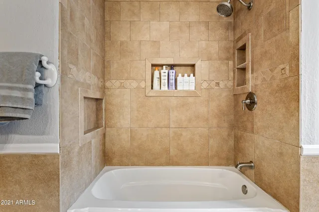 a bathroom with a granite countertop sink a toilet a mirror and bathtub