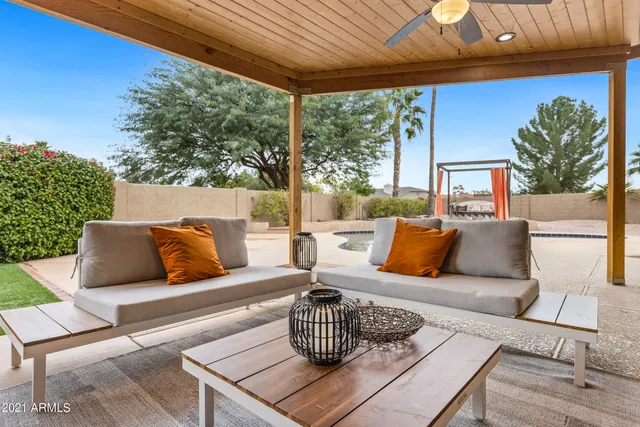 a view of a house with backyard and sitting area
