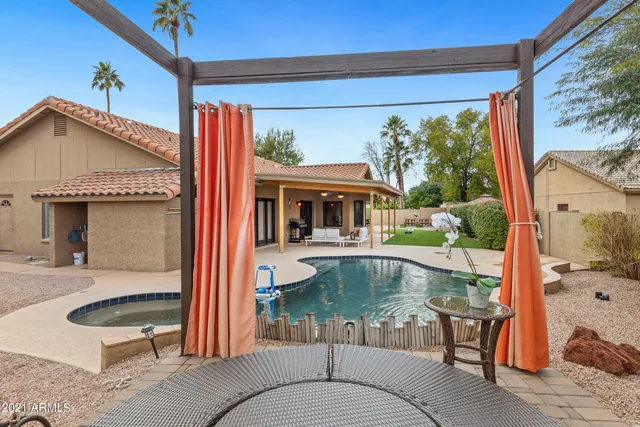 a view of a house with backyard and sitting area