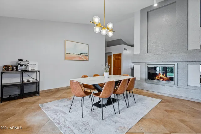 a dining room with wooden floor a chandelier a wooden table and chairs