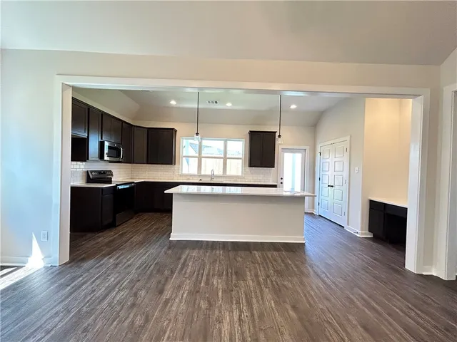 a large kitchen with a center island and stainless steel appliances