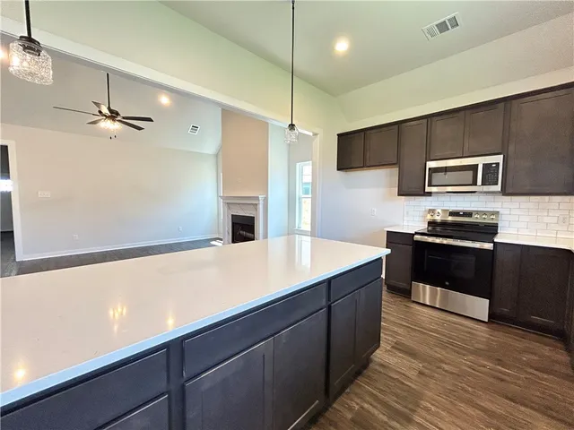 a kitchen with kitchen island a sink appliances and cabinets
