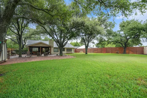 a view of a house with backyard and a tree