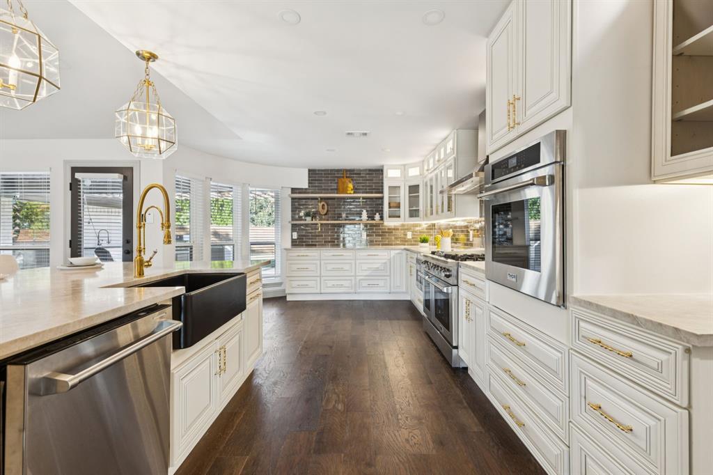 11023 Marsh Lane Dallas, TX 75229 - Photo 12 of 40 a large kitchen with stainless steel appliances granite countertop a lot of counter space and wooden floors