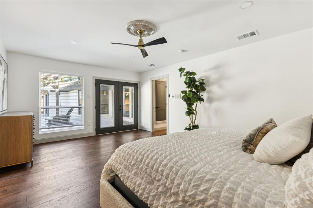 11023 Marsh Lane Dallas, TX 75229 - Photo 16 of 40 a bedroom with a large bed and wooden floor