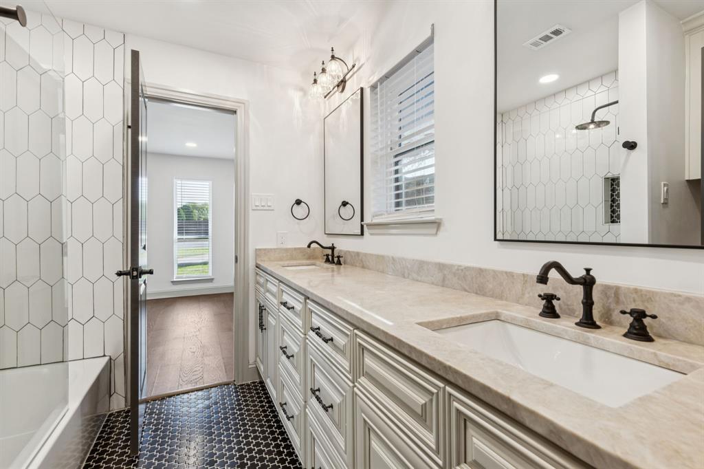 11023 Marsh Lane Dallas, TX 75229 - Photo 20 of 40 a bathroom with a double vanity sink a mirror and a shower
