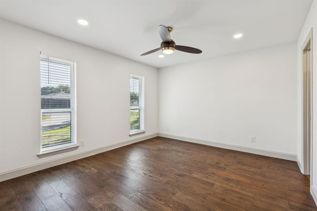 11023 Marsh Lane Dallas, TX 75229 - Photo 21 of 40 an empty room with wooden floor chandelier fan and windows