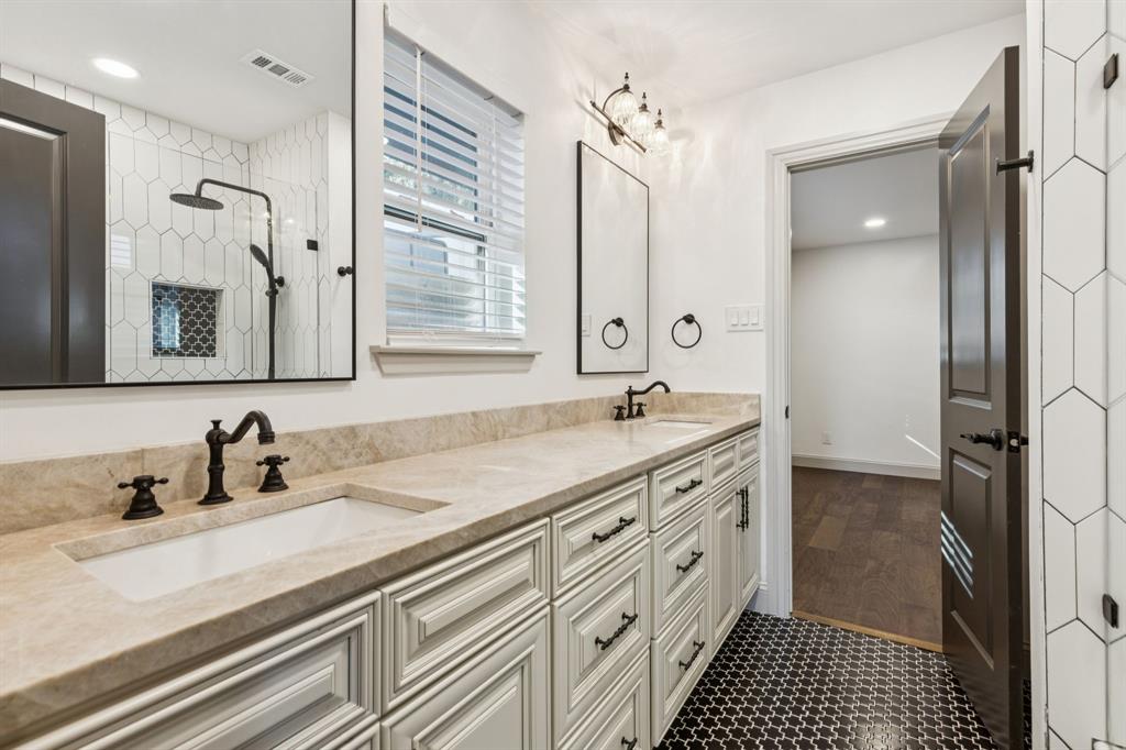 11023 Marsh Lane Dallas, TX 75229 - Photo 22 of 40 a bathroom with a double vanity sink a mirror and a shower