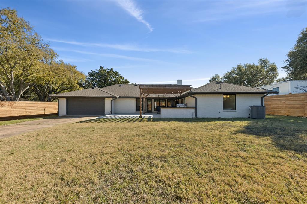 11023 Marsh Lane Dallas, TX 75229 - Photo 28 of 40 a backyard of a house with table and chairs under an umbrella