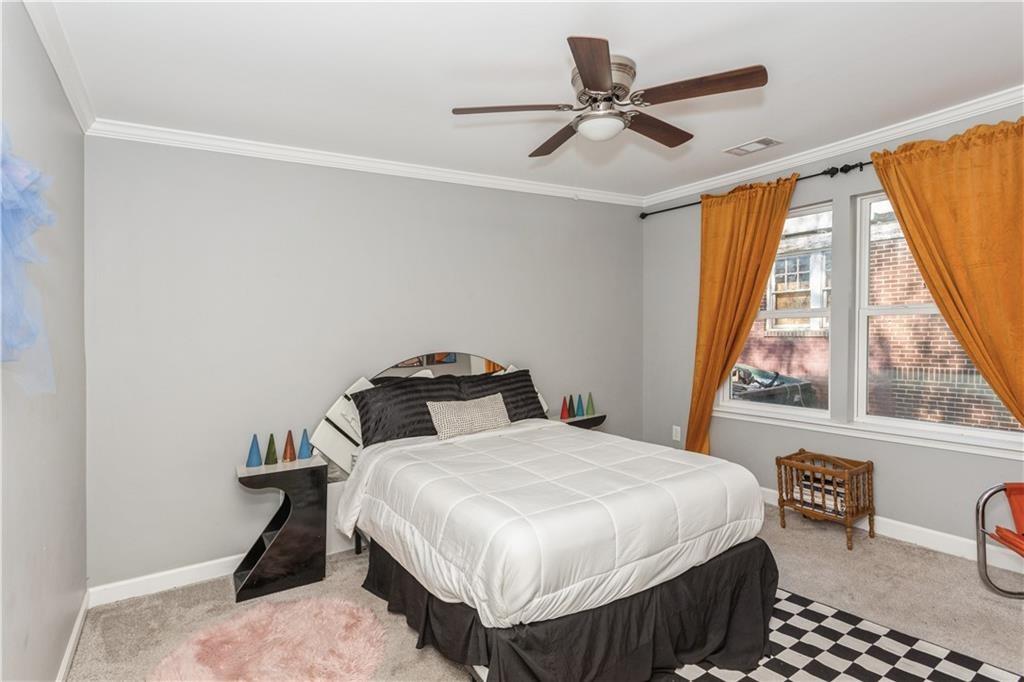 1184 Metropolitan Parkway Southwest Atlanta, GA 30310 - Photo 20 of 26 a bedroom with a bed a window and a chandelier