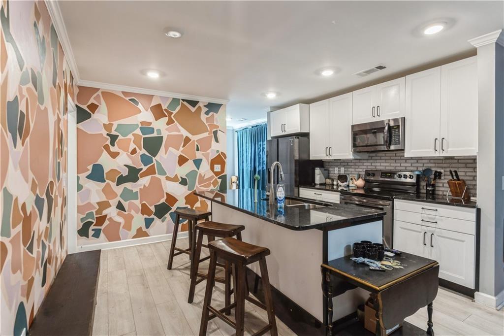 1184 Metropolitan Parkway Southwest Atlanta, GA 30310 - Photo 5 of 26 a kitchen with stainless steel appliances kitchen island granite countertop a refrigerator and a stove top oven