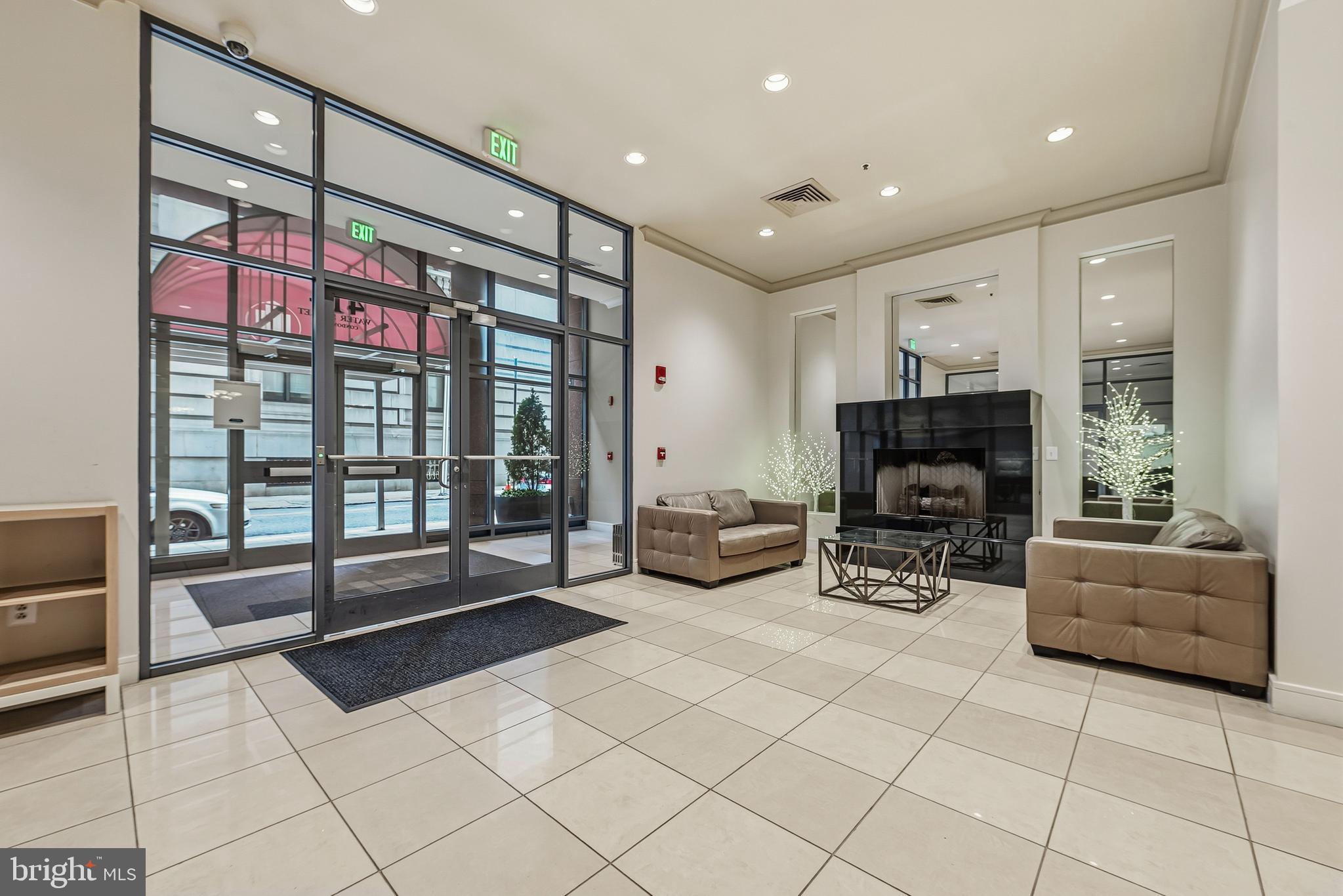 414 Water Street, Unit 1501 Baltimore, MD 21202 - Photo 4 of 35 a living room with furniture a flat screen tv and a floor to ceiling window