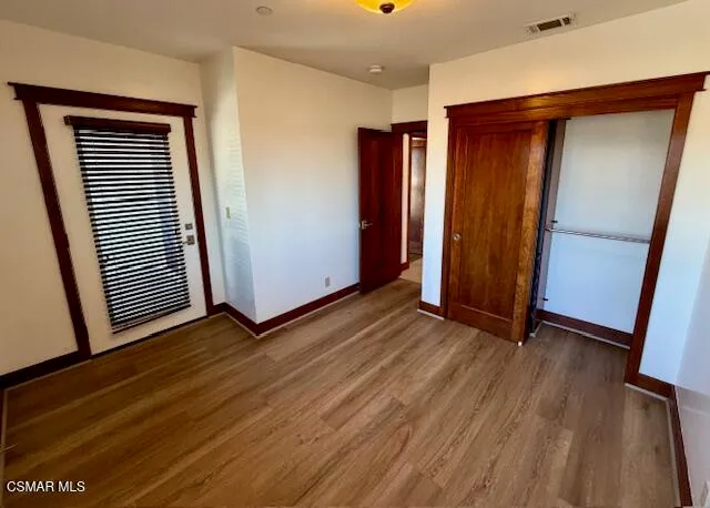 an empty room with wooden floor and closet