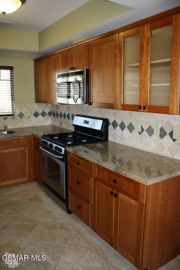 828 East Thompson Boulevard, Unit D Ventura, CA 93001 - Photo 4 of 24 a kitchen with granite countertop a sink and a stove