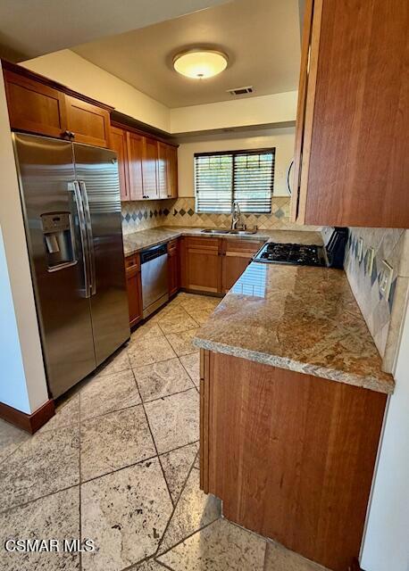 828 East Thompson Boulevard, Unit D Ventura, CA 93001 - Photo 5 of 24 a kitchen with stainless steel appliances granite countertop a refrigerator a stove and a sink with wooden cabinets