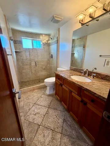 a bathroom with a granite countertop sink toilet and shower