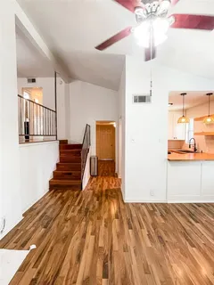 a view of a bedroom with wooden floor and staircase