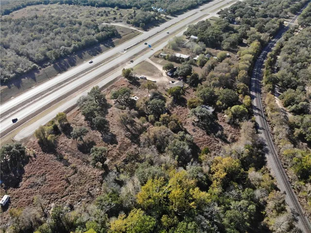 a view of a dry yard with trees