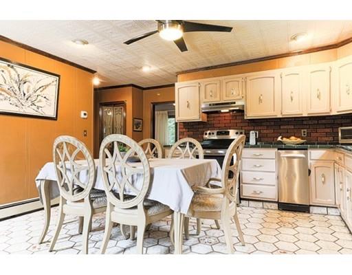32 Woodland Road Billerica, MA 01821 - Photo 4 of 19 a kitchen with stainless steel appliances kitchen island granite countertop a stove a refrigerator a dining table and chairs with wooden floor