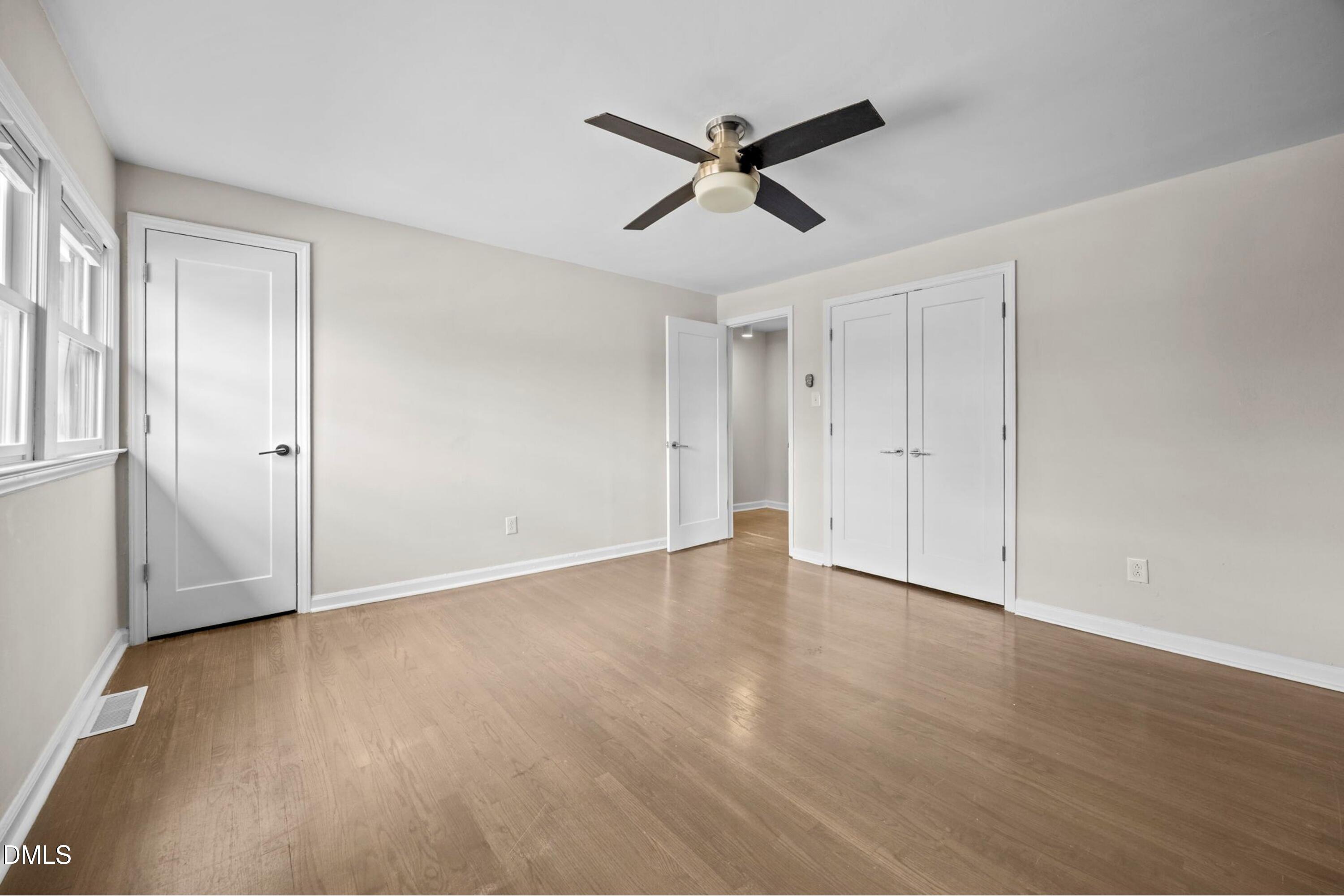 1618 Boyer Street Raleigh, NC 27610 - Photo 15 of 24 a view of an empty room with wooden floor and a ceiling fan