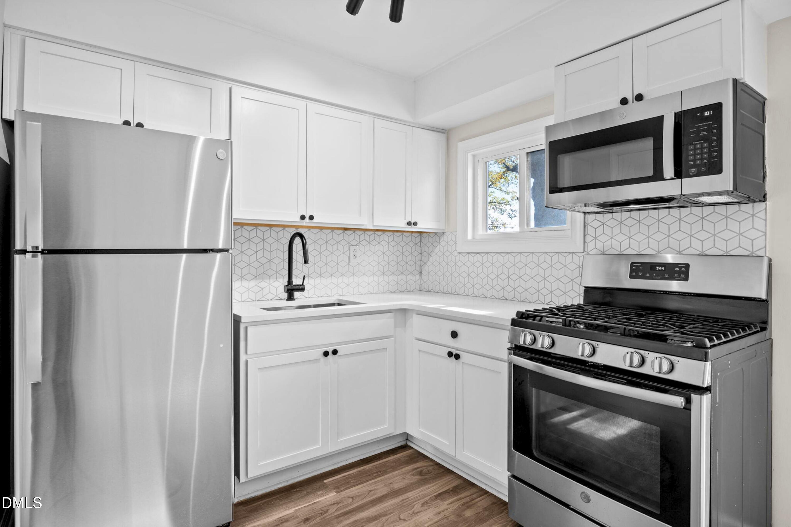 1618 Boyer Street Raleigh, NC 27610 - Photo 9 of 24 a kitchen with stainless steel appliances a refrigerator stove and microwave