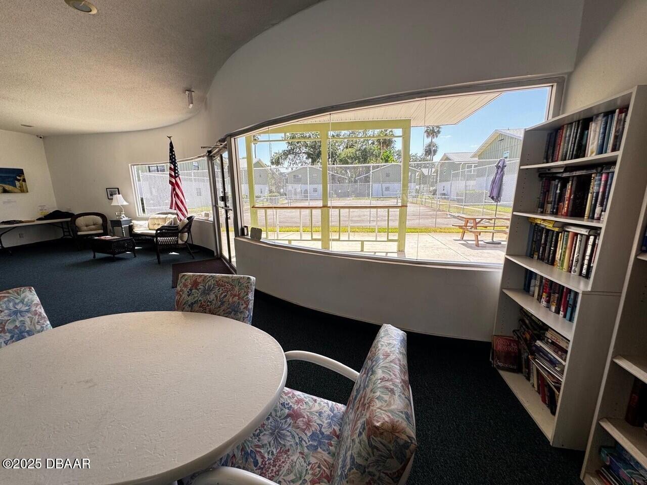 840 Center Avenue, Unit 980 Holly Hill, FL 32117 - Photo 12 of 13 a living room with furniture and a book shelf