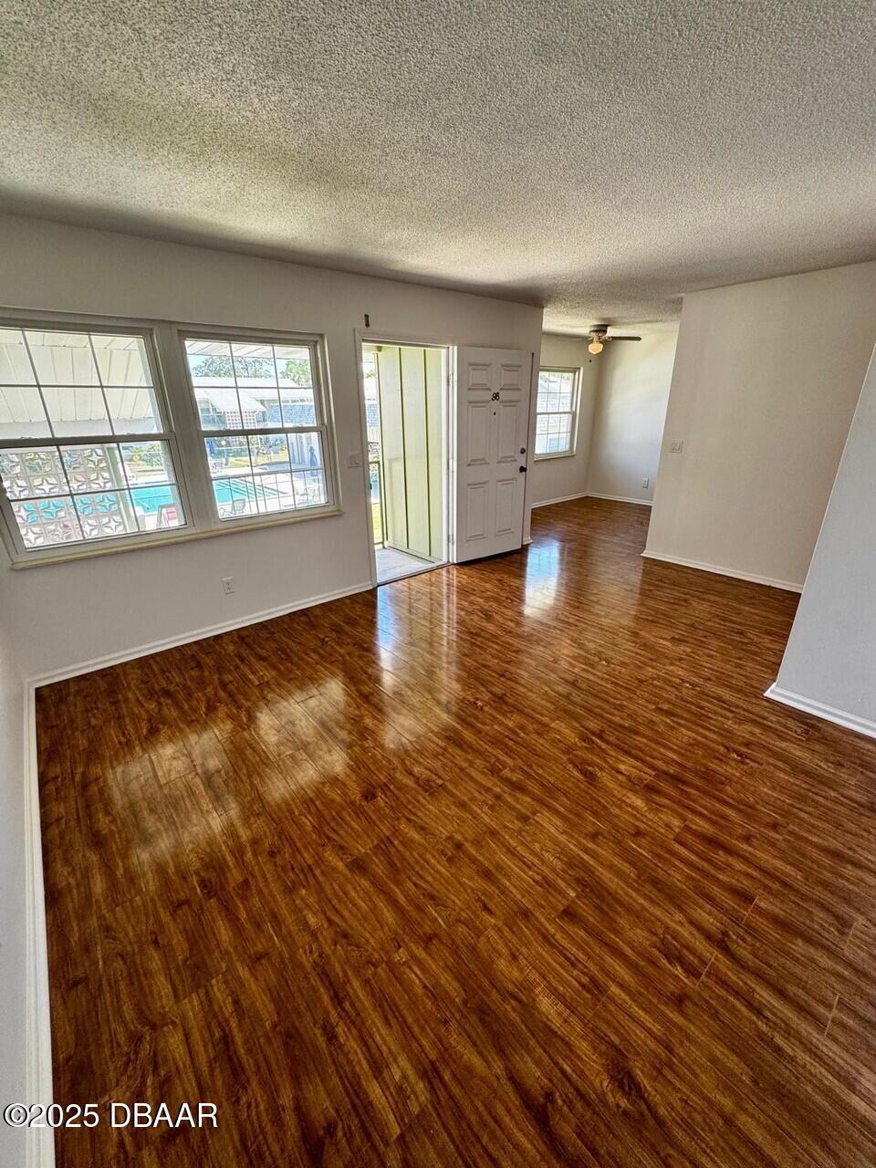 840 Center Avenue, Unit 980 Holly Hill, FL 32117 - Photo 7 of 13 an empty room with wooden floor and windows