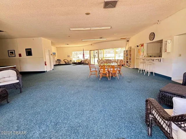 a view of a chairs and table in patio with a swimming pool
