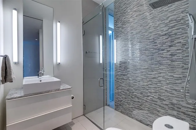 a bathroom with a granite countertop sink toilet and shower