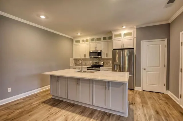 a kitchen with kitchen island a sink appliances and cabinets