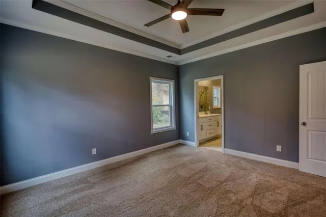a view of an empty room with window and chandelier fan