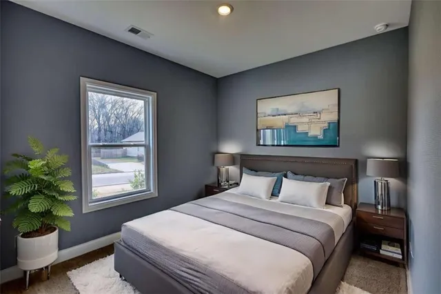 a bedroom with a bed and a potted plant