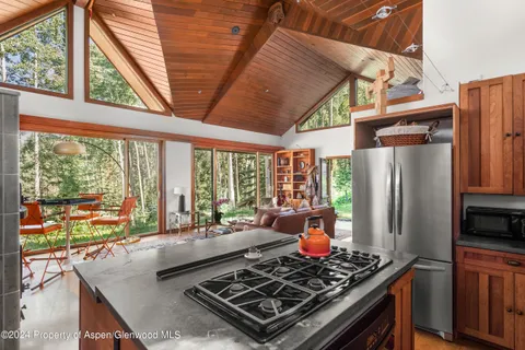 a kitchen with stainless steel appliances granite countertop a stove a refrigerator and a wooden cabinets