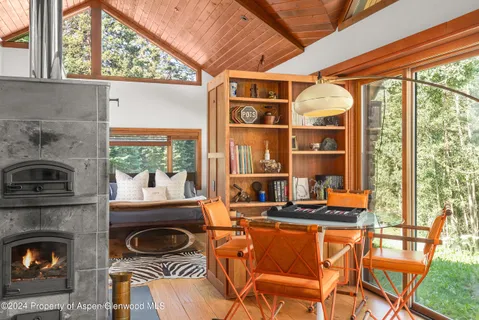a dining room with a fireplace a flat screen tv and outdoor view