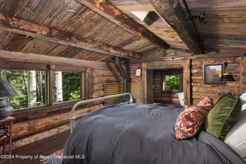 a spacious bedroom with a bed and wooden floor