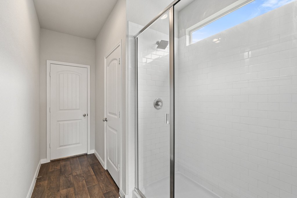 102 Ashford Way Georgetown, TX 78626 - Photo 15 of 28 A spacious, contemporary shower enclosure features bright subway tile and a high window for natural illumination.