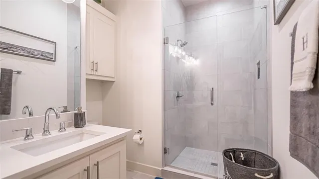 a bathroom with a sink a toilet a mirror and shower
