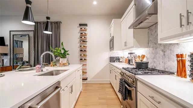 a kitchen with stainless steel appliances a sink stove and cabinets