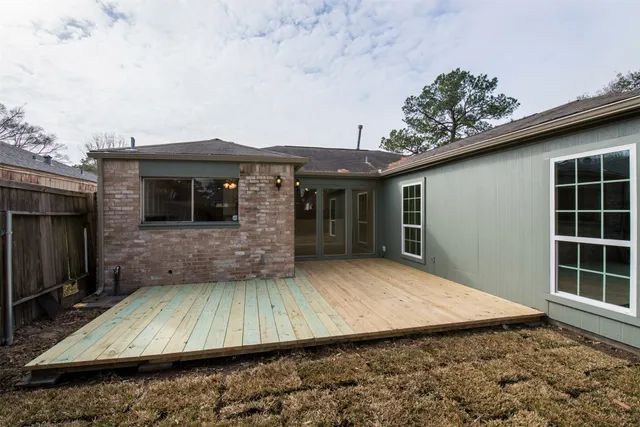 a view of a house with a large window and wooden fence