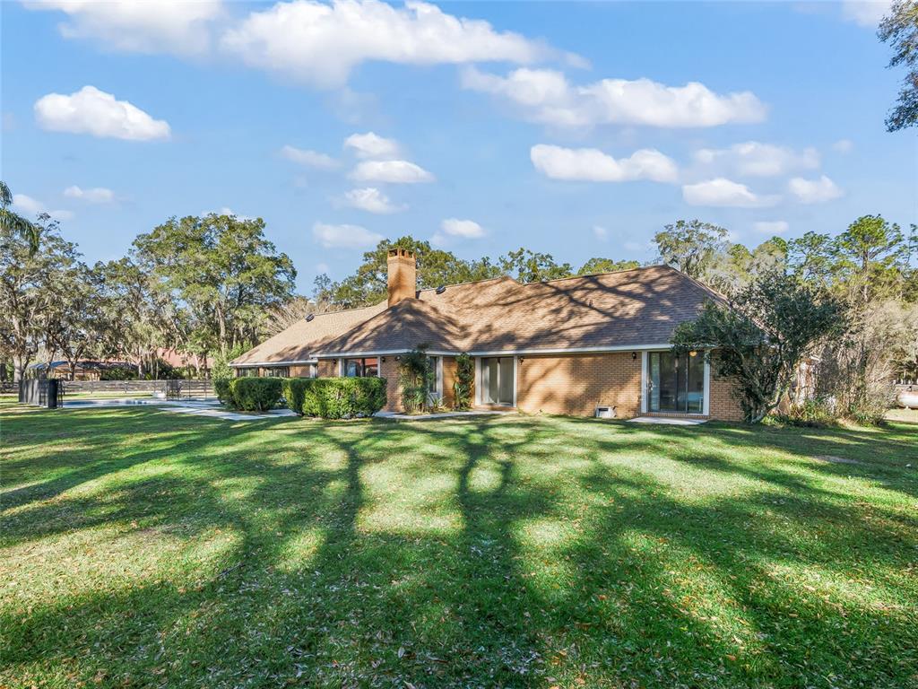 680 Southeast 123rd Street Road Ocala, FL 34480 - Photo 37 of 48 a view of a house with a big yard and large trees