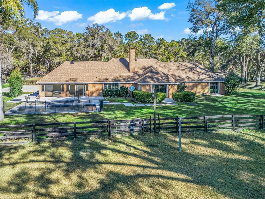 680 Southeast 123rd Street Road Ocala, FL 34480 - Photo 38 of 48 a front view of a house with a garden and lake view
