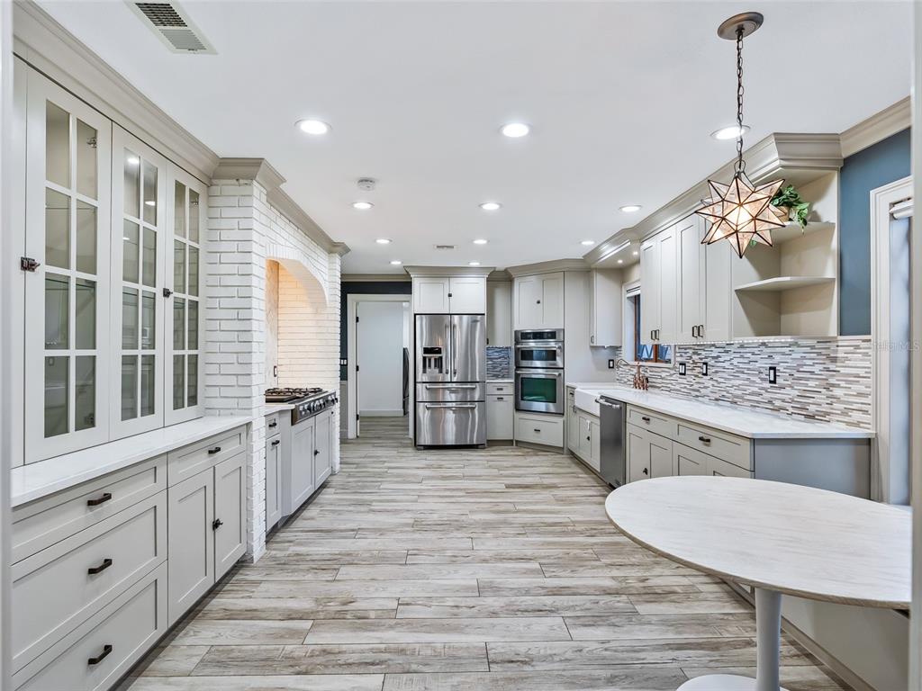680 Southeast 123rd Street Road Ocala, FL 34480 - Photo 10 of 48 a large kitchen with kitchen island a stove a sink a dining table and chairs