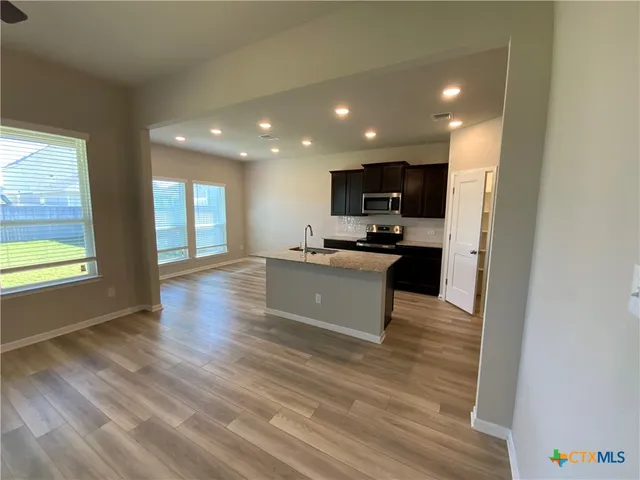a view of kitchen with microwave refrigerator and stove
