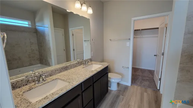 a bathroom with a granite countertop sink toilet and shower