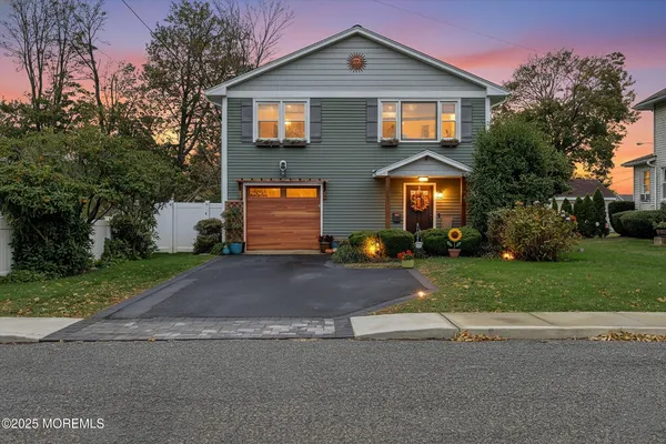 a front view of a house with a yard and a garage