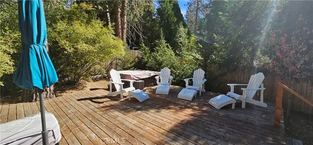 a view of a patio with table and chairs with wooden floor and fence