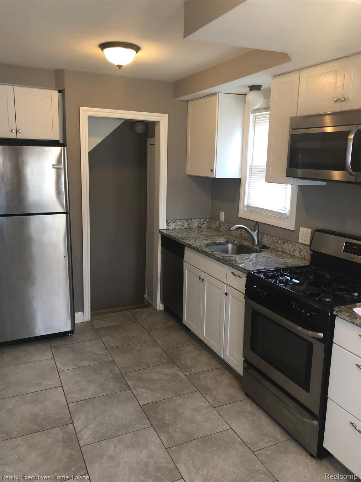 2427 Cambridge Road Berkley, MI 48072 - Photo 8 of 17 Kitchen featuring stainless steel appliances, white cabinetry, speckled countertops, and tile flooring